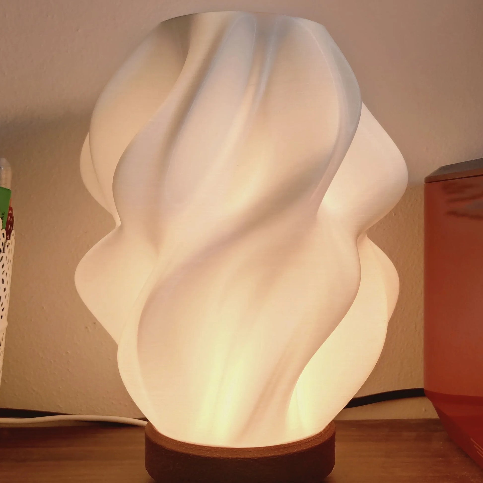Ovarana Sanjh table lamp lit on a wooden desk beside a pen pot